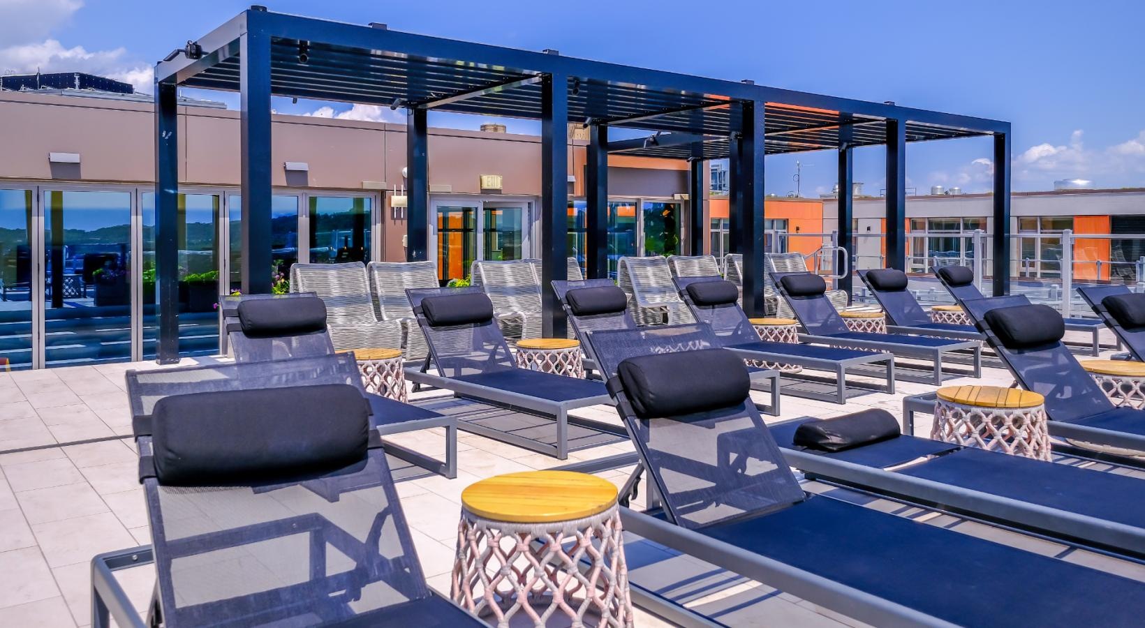 Relax and unwind poolside lounge chairs and tables on rooftop