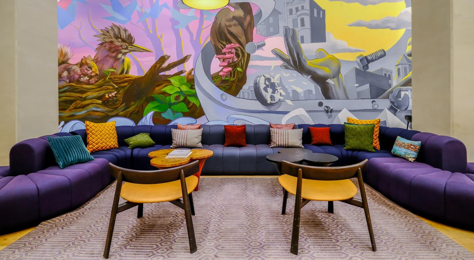 Everything within reach couches and chairs in front of a mural